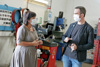 Landesrätin Birgit Gerstorfer im Gespräch mit Vehikel-Geschäftsführer Martin Beck, in einer Werkstatt, beide tragen einen Mund-Nasen-Schutz 