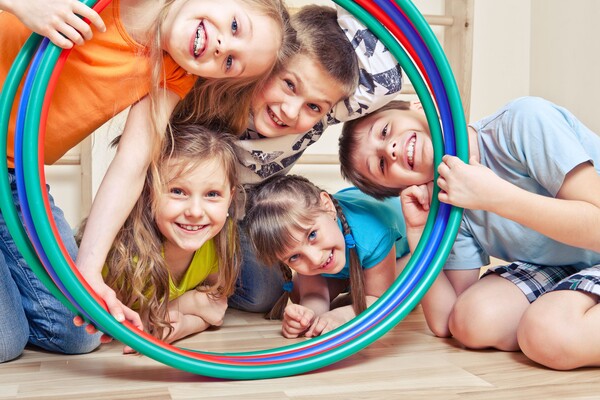 Fröhliche Kinder schauen durch einen Hula-Hoop-Reifen
