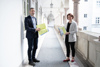 Stephan Wöckinger und Landesrätin Michaela Langer-Weninger stehen auf einem Gang im Arkadenhof des Linzer Landhauses, beide halten eine Mappe mit Informationsmaterial in Händen