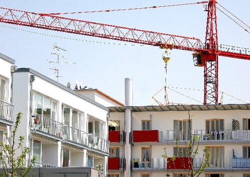 Modernes mehrgeschossiges Wohnhaus, im Hintergrund Baukran 