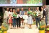 LR Michaela Langer-Weninger und Karl Ploberger stehen mit den Preisträgerinnen und Preisträger nach der Preisübergabe auf der Gartenland-geschmückten Bühne. Ein Teil der Personen hält einen Blumenstrauß bzw. eine A4-Scheckkarte in den Händen.