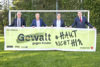 Peter Reichl, Franz Schiefermair, Landesrat Mag. Michael Lindner und DI Erich Haider stehen nebeneinander vor einem Fußballtor und halten gemeinsam ein großes Plakat mit Beschriftung Gewalt gegen Kinder #haut nicht hin