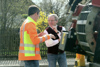 Landesrat Ing. Wolfgang Klinger mit einem Gemeindemitarbeiter im Gespräch auf einer Siedlungsstraße, im Hintergrund ein Zaun, Bäume und ein Haus