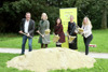 Bernhard Zwielehner, Landeshauptmann-Stellvertreterin Mag.a Christine Haberlander, Landesrätin Birgit Gerstorfer, Susanne Billinger und Michaela Schrotter stehen nebeneinander auf einer Wiese hinter einem Sandhügel, alle halten jeweils einen Spaten in Händen und werfen damit Sand 