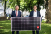 Landeshauptmann Mag. Thomas Stelzer und Landesrat Stefan Kaineder stehen nebeneinander in einem Park und halten gemeinsam ein Solarpanel