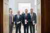 Vizebürgermeister Martin Hajart, Bürgermeister Klaus Luger, Landeshauptmann Thomas Stelzer und Landesrat Günther Steinkellner stehend an einer Tür im Linzer Landhaus.