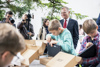 Landeshauptmann Mag. Thomas Stelzer mit Schülerinnen und Schülern des BG/BRG Ramsauerstraße, die gerade an einem Tisch im Freien die neuen Laptops auspacken, im Hintergrund Fernsehkameras.