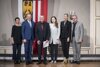 Mag.a Sigrid Mitterbauer, Landeshauptmann Mag. Thomas Stelzer, Wolfgang Mayrhofer, Mona Rozdestvenskyte, MA, Mag.a Barbara Wolfmayr und MMag. Harald Wurmsdobler stehen nebeneinander in einem barocken Raum, im Hintergrund Oberösterreich-Fahne