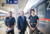 Daniel Moser, Landeshauptmann Mag. Thomas Stelzer und Dennis Moro stehen nebeneinander auf einem Bahnsteig; rechts von ihnen steht ein Zug.