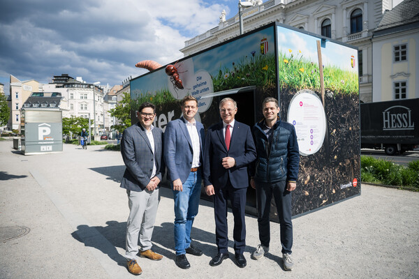 Markus Altenhofer, Abteilung Umweltschutz des Landes OÖ, Umwelt-Landesrat Stefan Kaineder, Landeshauptmann Thomas Stelzer, und Thomas Bauer, Abteilung Umweltschutz des Landes OÖ, vor dem Bodencubus im Landhauspark.