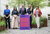 Sara Ostertag, Julia Ransmayr, Landeshauptmann Mag. Thomas Stelzer, Mag.a Margot Nazzal und Mag.a Anja Lang stehen nebeneinander in einem begrünten Innenhof und halten ein Plakat mit Beschriftung Schäxpir Festival Linz, Magic Magic