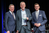 Landeshauptmann Thomas Stelzer, Gerhard Straßer mit dem Silbernen Ehrenzeichen des Landes Oberösterreich, und Wirtschafts-Landesrat Markus Achleitner stehend im Steinernen Saal des Landhauses.