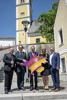 St. Florians Bürgermeister Bernd Schützeneder, der künstlerische Leiter des Bruckner-Jahrs 2024 Norbert Trawöger, Landeshauptmann Thomas Stelzer, Kulturdirektorin Margot Nazzal und Ansfeldens Bürgermeister Christian Partoll mit dem Logo des Bruckner-Jahrs 2024 in Form einer Oberösterreich-Karte vor dem Geburtshaus von Anton Bruckner in Ansfelden.