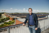 Landesrat Stefan Kaineder auf einer Dachterrasse, im Hintergrund Sonnenkraftwerksdächer