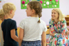 Landeshauptmann-Stellvertreterin Mag.a Christine Haberlander in einem Kindergartenraum im Gespräch mit drei Kindern