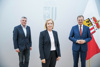 Landesamtsdirektor Dr. Erich Watzl,  Mag.a Carmen Breitwieser und Landeshautmann Mag. Thomas Stelzer vor einer Oberösterreich-Fahne