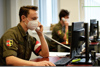zwei Soldaten in Uniform sitzen mit FFP2-Maske vorm PC und telefonieren