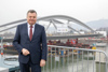 Landesrat Mag. Günther Steinkellner, im Hintergrund die Brückenbaustelle für die Neue Eisenbahnbrücke in Linz