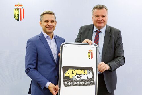 Landesrat Dr. Wolfgang Hattmannsdorfer und Landesrat Mag. Günther Steinkellner stehen nebeneinander und halten ein großes Smartphoneplakat mit der Aufschrift „4youcard - Die Jugendkarte des Landes OÖ“ in der Hand.