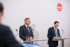 Landeshauptmann Thomas Stelzer und Landeshauptmann-Stellvertreter Manfred Haimbuchner stehend bei der Pressekonferenz.