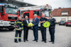 Lena Höll, Bernd Schützeneder, Landeshauptmann Mag. Thomas Stelzer, Ronald Winkler und Robert Mayer stehen nebeneinander vor einem Zeughaus mit zwei Feuerwehrfahrzeugen