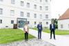 Konsulentin Dr.in Brigitte Kepplinger, LH Mag. Thomas Stelzer und Mag. Florian Schwanninger stehen vor dem Gebäudeeingang „Lern- und Gedenkort Schloss Hartheim“ 