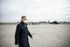 Landeshauptmann Mag. Thomas Stelzer auf einem Flugplatzgelände, im Hintergrund ein Militär-Hubschrauber