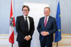 Bundesminister Dr. Martin Polaschek und Landeshauptmann Mag. Thomas Stelzer stehen nebeneinander vor einem Rollplakat des Bundesministeriums für Bildung, Wissenschaft und Forschung, flankiert von der Österreich- und der EU-Flagge.