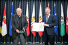 Christian Ludwig Attersee mit Landeshauptmann Mag. Thomas Stelzer mit Urkunde und Medaille, im Hintergrund Fahnen von Oberösterreich, der Bundesländer und der Europäischen Union