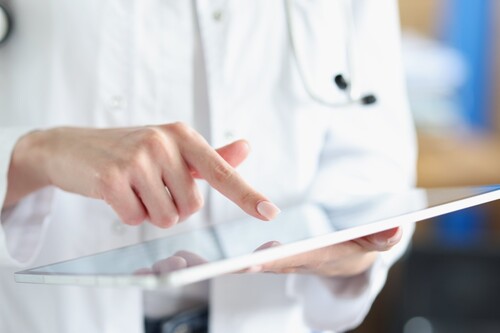 Ärztin deutet mit ihrem Finger auf ein Tablet