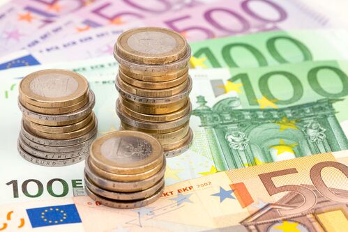 Geldscheine und übereinandergestapelte Euromünzen