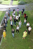 Gruppenbild, von oben fotografiert, Menschen stehen auf einer Rasenfläche, Sozial-Landesrätin Birgit Gerstorfer (vorne rechts) mit Direktorin Wilma Steinbacher (dieses steht vorne links), dahinter in regelmäßigen Abständen Schülerinnen und Schüler