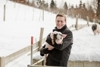 LR Kaineder steht in einer Winterlandschaft und hält ein Ferkel in der Hand.