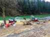Zwei rot-graue Bagger graben Erde aus einem Fluss