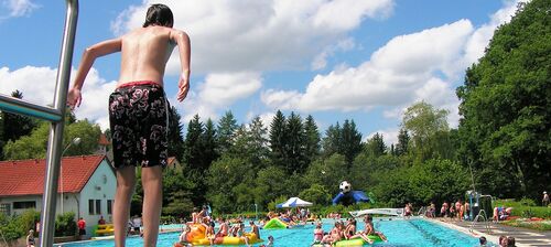 Freibad, Bub springt in ein Schwimmbecken 