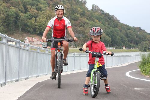 Radfahrer und Kind testen den neuen Radweg