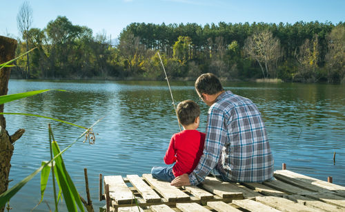 Vater und Sohn fischen an einem See.