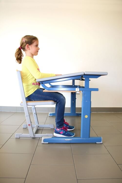 Mädchen sitzt ergonomisch richtig am Schreibtisch