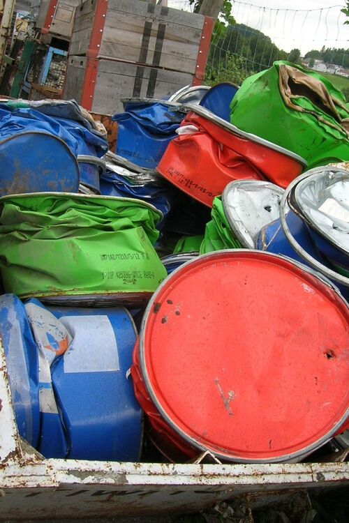 Abfallsammlung - gepresste Metallfässer in einem Container