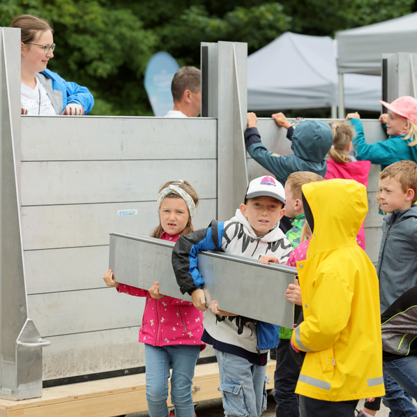 Kinder beim Aufstellen einer Hochwasserschutzwand