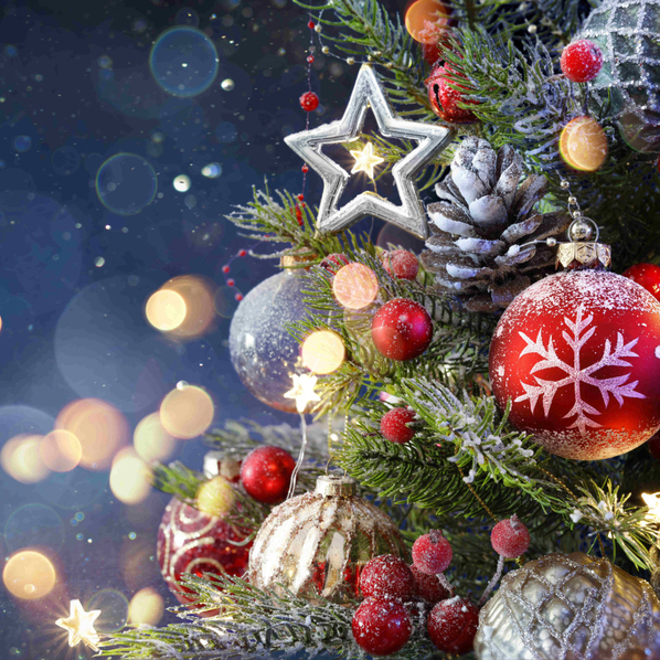 Ausschnitt eines Weihnachtsbaums mit dezenter Beleuchtung im Hintergrund