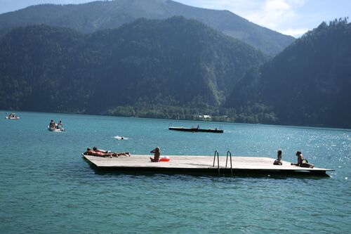 Badegäste auf Holzplattform im Attersee