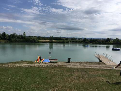 Badesee Mitterkirchen mit Sprungturm aus Beton und großer schwimmender Gummiinsel 