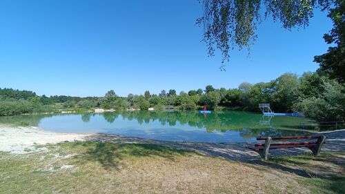 Badesee Mining_mit Sandstrand und schwimmendem Sprungturm mit roter Leiter