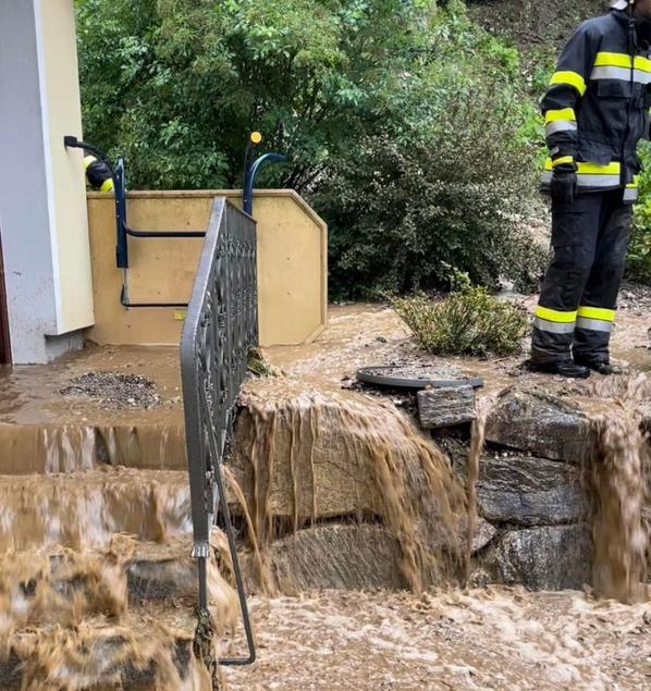 Hangwasser überschwemmt einen Gehweg mit Treppe
