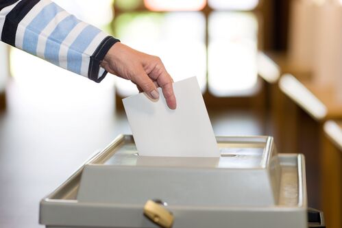 Stimmzettel wird in eine Wahlurne geworfen. Stimmzettel wird in eine Wahlurne geworfen.