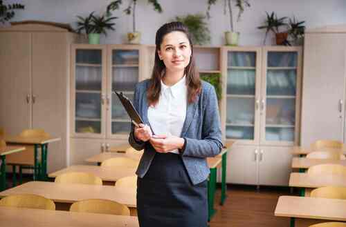 Lehrerin steht in einem Klassenzimmer