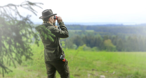 Jägerin beobachet mit einem Fernglas