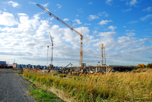 Baustelle mit mehreren Kränen auf einem Feld