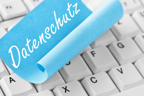 Auf einer Tastatur klebt ein hellblaues Post-it mit der Aufschrift 'Datenschutz'